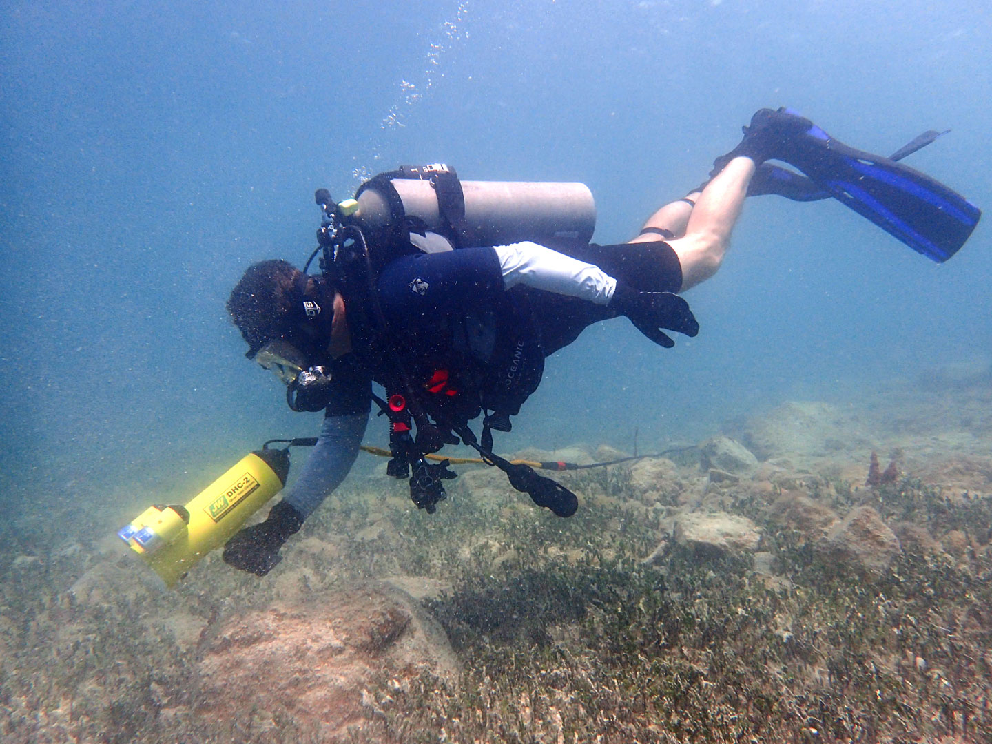 A diver under water using a Diver Held Camera (DHC)